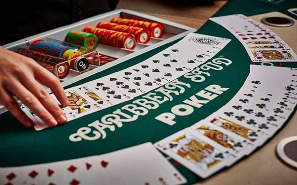 Bàn đánh bài Caribbean Stud Poker với màu sắc sống động và thẻ bài được xếp chồng lên nhau trên bàn